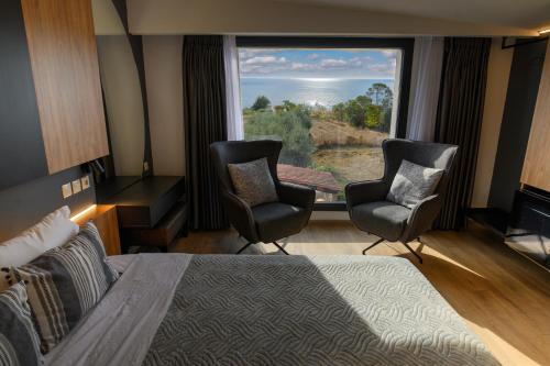 a hotel room with two chairs and a large window at Endless View loft in Mesimvría