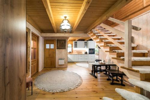 a living room with a wooden staircase and a table at Siedlisko Sapunki dom z duszą rybaka na Warmii in Bogdany