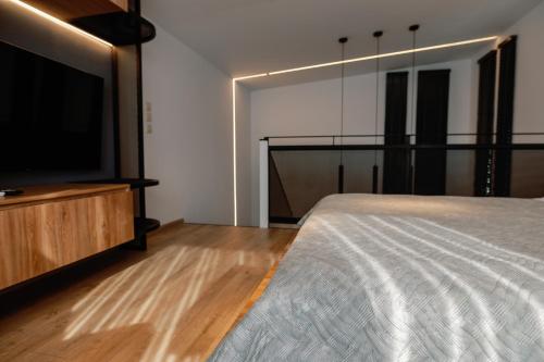 a bedroom with a bed and a flat screen tv at Endless View loft in Mesimvría