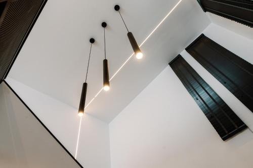 a cluster of lights hanging from a white wall at Endless View loft in Mesimvría