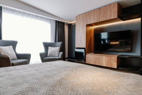 a hotel room with a bed and a flat screen tv at Endless View loft in Mesimvría