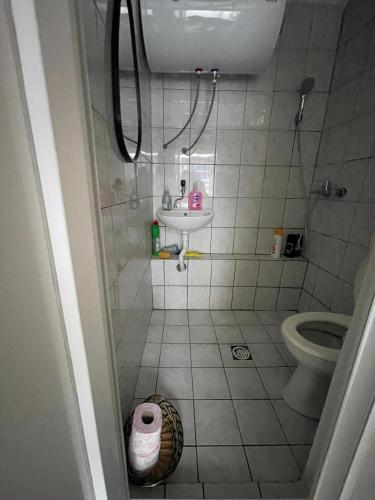 a small bathroom with a toilet and a sink at Comfort Studio Prishtina City Centre in Pristina