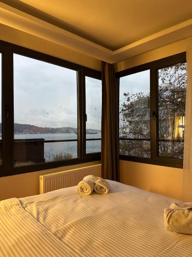 a bedroom with two towels on a bed with windows at Lokka Hotel Ortakoy in Istanbul