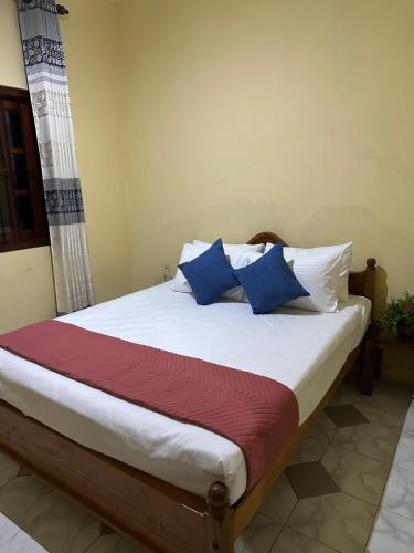 a bed with blue and white pillows in a room at Mount House Galle in Galle