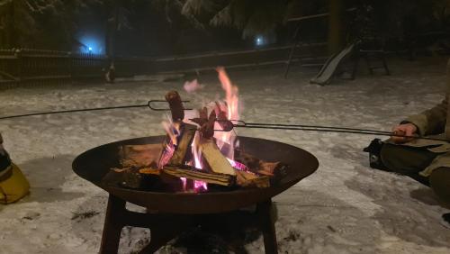 a fire pit in the snow at night at Stará Škola Hedeč in Králíky