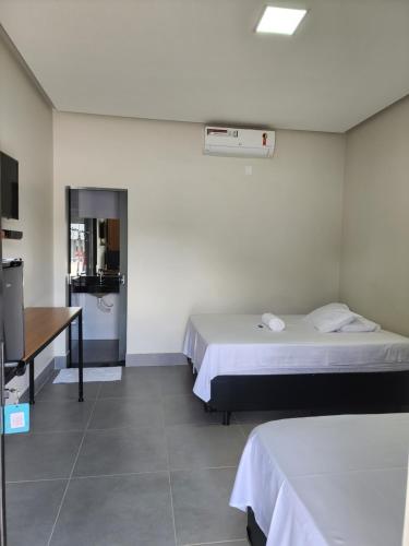 a room with two beds and a desk in it at Hotel friper in Jaraguá