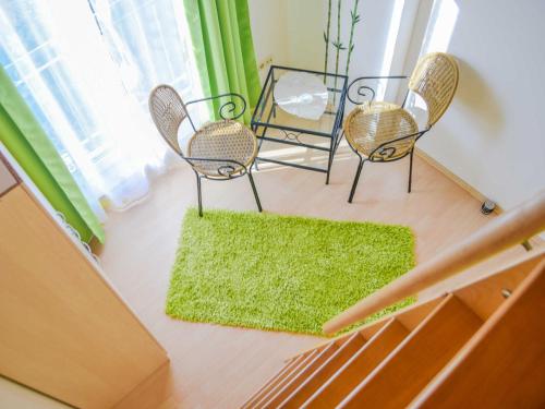 a living room with two chairs and a green rug at Ferienhaus Bodden in Neuendorf