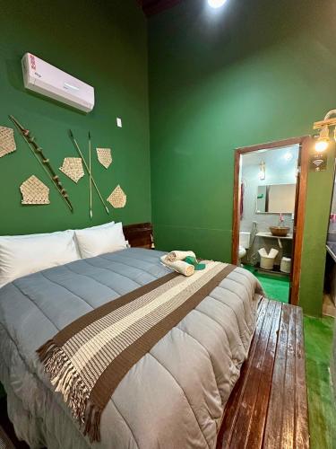 a bedroom with a large bed with a green wall at Dona Nilza Hotel Fazenda in Brasilia