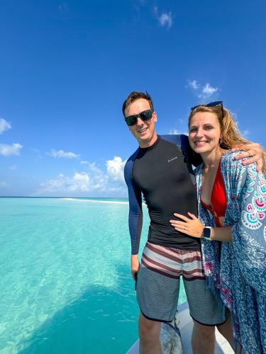 a man and a woman standing on a boat in the water at Ukulhas Sands in Ukulhas