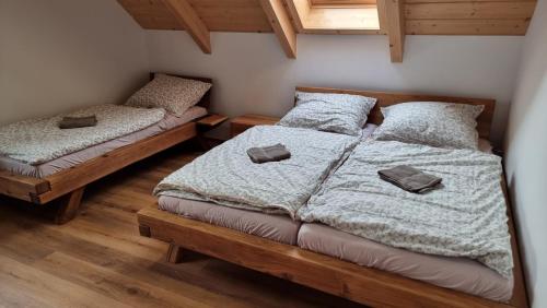 two beds in a room with wooden floors at Krušnohorská roubenka in Karlovy Vary