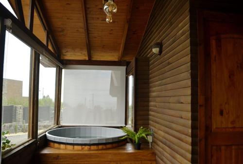 a large tub in a room with a large window at Altos de Pichilemu in Pichilemu