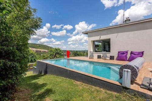 - une piscine avec des oreillers violets à côté d'une maison dans l'établissement House with swimming pool near Lyon, à Rochetaillée