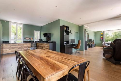 Il dispose d'une cuisine et d'un salon avec une table et des chaises en bois. dans l'établissement House with swimming pool near Lyon, à Rochetaillée