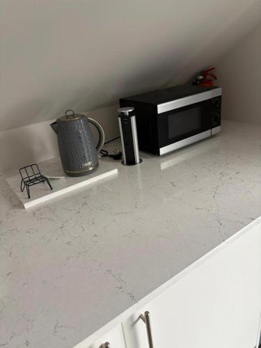 a counter top with a microwave and a tea kettle at Lisburn - 1 Bedroom - sleeps 2 - Street parking in Lisburn
