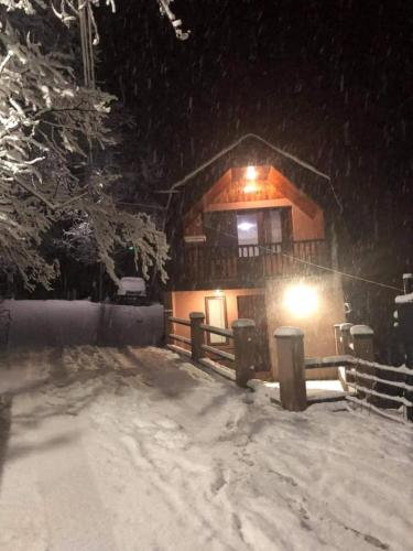 a log cabin in the snow at night at Likani house in Borjomi
