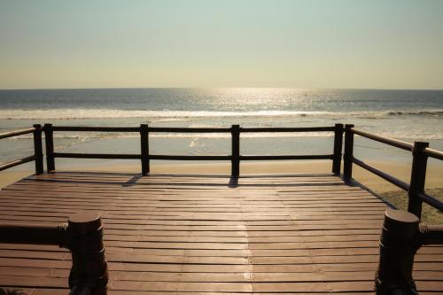 a wooden boardwalk on the beach with the ocean at Refugio de piedra - Troncones in Troncones