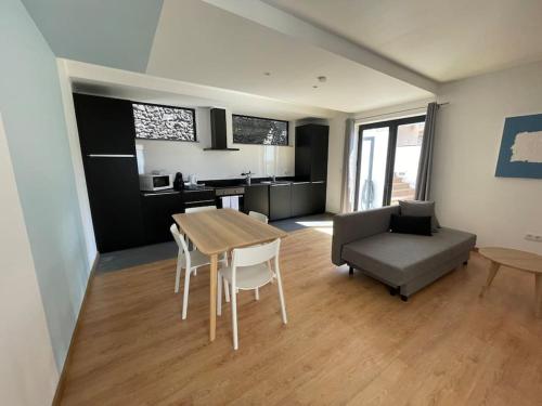 a kitchen and living room with a table and a couch at Ocean T1 Vista Mar e Piscina em Varadouro Faial in Capelo