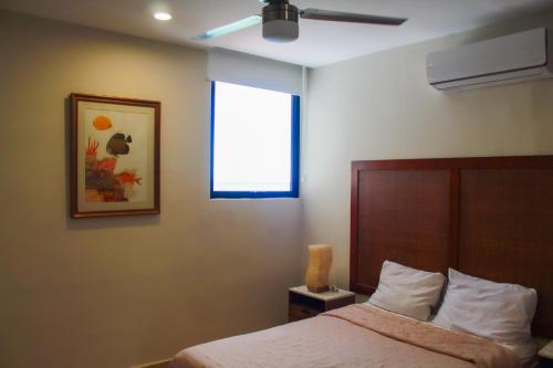 a bedroom with a bed and a window at Sifnos Spacious Apartment close Chicxulub in Chicxulub