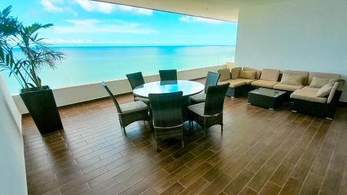 a dining room with a table and chairs and a couch at Sifnos Spacious Apartment close Chicxulub in Chicxulub