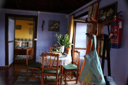 a dining room with a table and chairs and a guitar at Casa Asuncion in Breña Alta