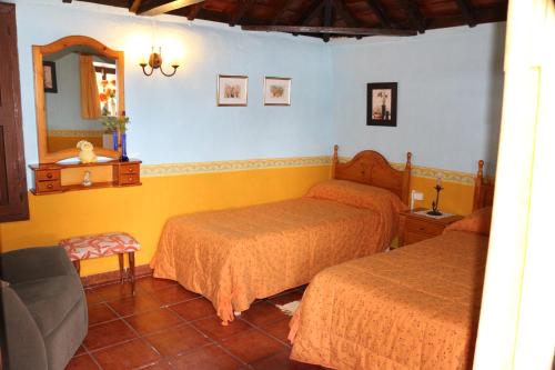 a bedroom with two beds and a mirror at Casa Asuncion in Breña Alta