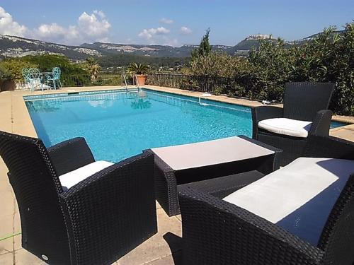 une piscine avec deux chaises et une table dans l'établissement Villa Cassis 1-6 pers proche Marseille et Parc national des Calanques, à Cassis