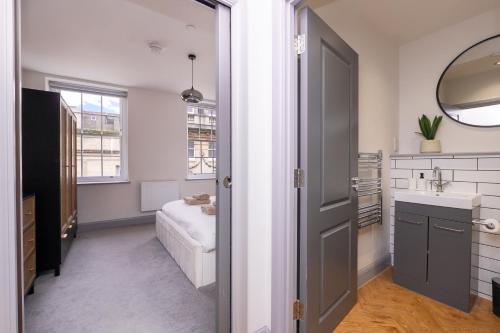 a bathroom with a sink and a mirror at Bath Street Penthouse in Bath