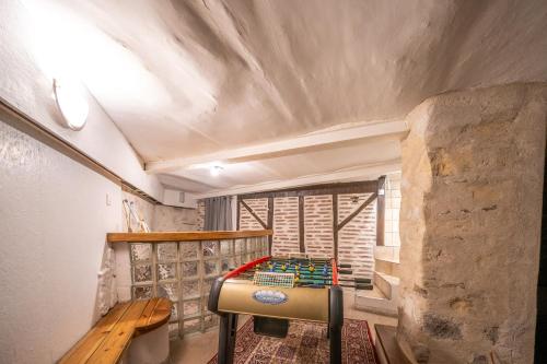 une chambre avec une table et un banc sur un balcon dans l'établissement Maison de Brique- CINEMA ROOM-BABY-FOOT - 10min à pieds Gare RER A- TRÈS PROCHE ARENA LA DEFENSE ET PARIS, à Houilles