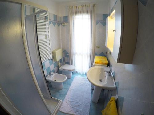 a bathroom with a sink and a toilet and a mirror at Residence Pineta - Agenzia Cocal in Caorle