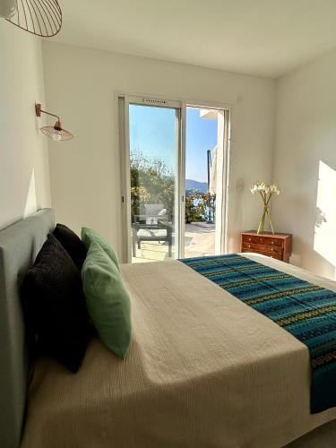 - une chambre avec un lit et une vue sur une terrasse dans l'établissement Appartement à 2mn de la plage du Ruppione, à Pietrosella