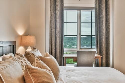 a bedroom with a bed and a large window at Tremblant Prestige - Equinoxe 170-7 in Mont-Tremblant