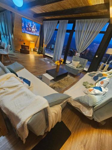 a large room with two beds and a large window at Cabana Apuseni Wild in Valea Lupşei