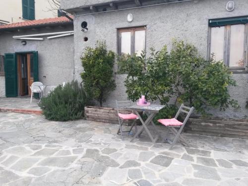 a table and chairs in front of a house at Agriturismo OlivArancio in Leivi