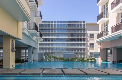 an apartment building with a swimming pool in front of it at CC Loft in Mandurriao