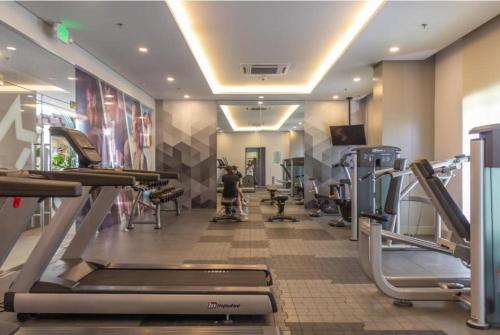 a gym with cardio equipment and a person on a treadmill at CC Loft in Mandurriao