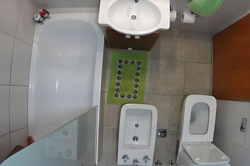 a bathroom with a white toilet and a sink at Casa Lego in Dina Huapi