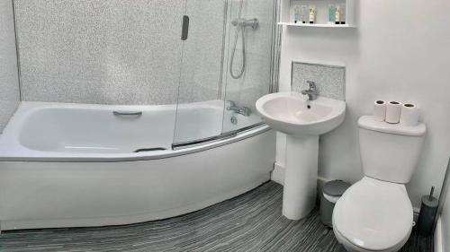 een badkamer met een bad, een wastafel en een toilet bij The Royal Oak Cottages in Hunmanby