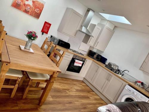 een keuken met een houten tafel met stoelen en een fornuis bij The Royal Oak Cottages in Hunmanby