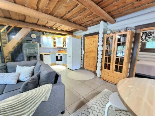 a living room with a couch and a table at Tunnelmallinen hirsimökki - Levin Liitäjä in Kittilä