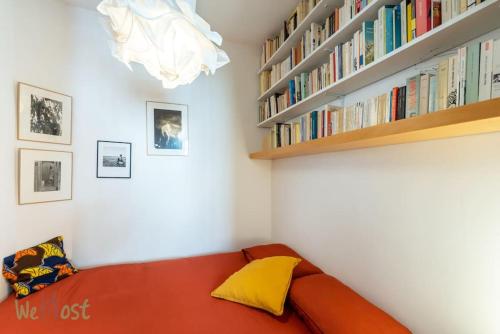 - un canapé rouge dans une chambre avec une étagère dans l'établissement Nice apartment for 2p in Montmartre district, à Paris