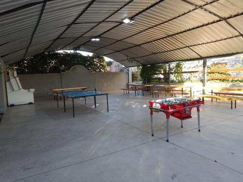 a patio with ping pong tables and benches at Nuevo Centro Hotel Villa Carlos Paz in Villa Carlos Paz