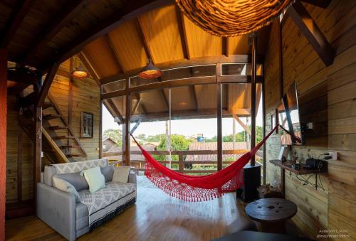 a living room with a hammock in a house at Morada de Rashid - Com Banheira de Imersão in Praia do Rosa