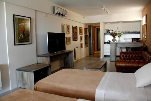 Habitación de hotel con cama y sala de estar. en Rivadavia Apartment en Buenos Aires