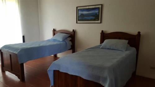 two twin beds in a room with a window at Casita en la finca Los Bambú in Jaris