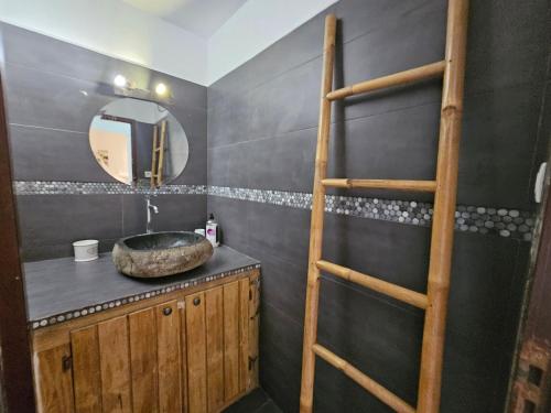 a bathroom with a sink and a wooden ladder at Studio Nina, accès plage et piscine in Cul de Sac