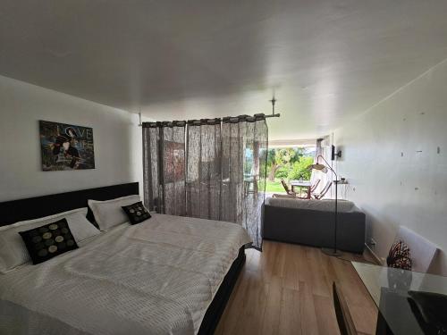 a bedroom with a bed and a window at Studio Nina, accès plage et piscine in Cul de Sac