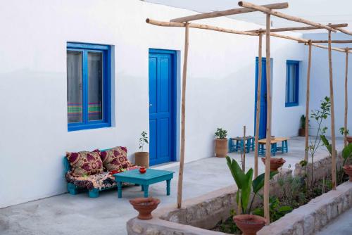 a patio with blue doors and a couch at IBI Surf House in Sidi Kaouki