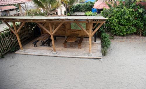 a wooden pavilion with chairs and a table at La Casa Mompiche in Mompiche