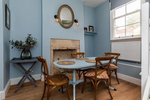 a dining room with a table and chairs and a fireplace at Charming Cottage - Country Views in Bath