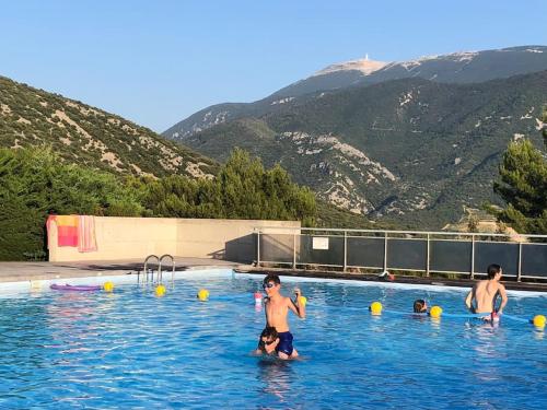 un groupe de personnes jouant dans une piscine dans l'établissement Bastidon La Garrigue, à Mollans-sur-Ouvèze